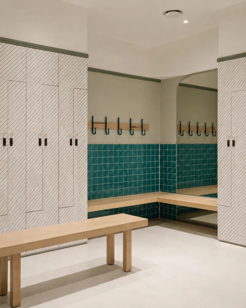 Changing rooms with striped stone lockers, teal tiles and oak benches