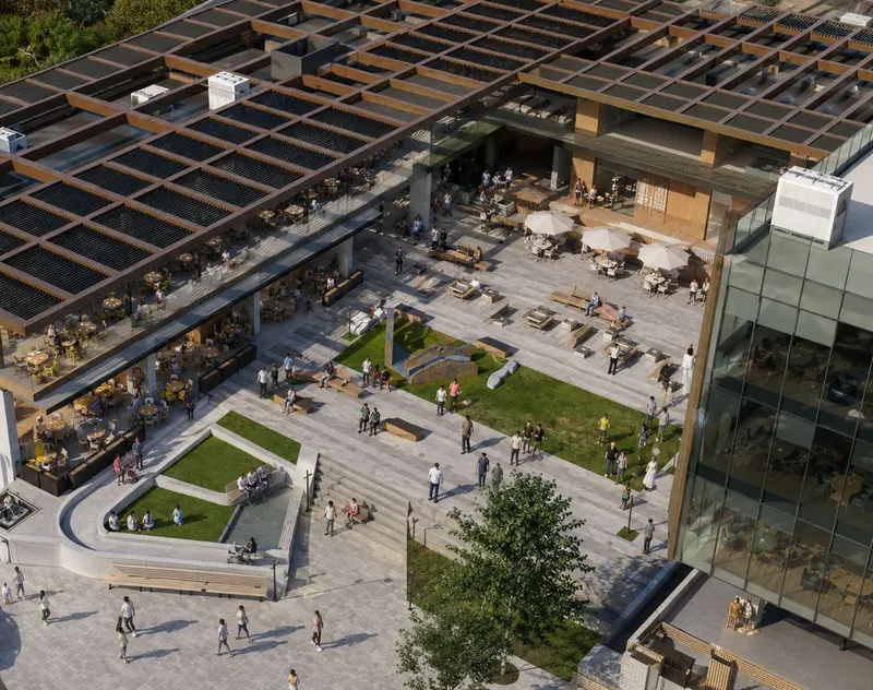 Aerial view of a food hall under a timber pergola roof, with terraces, lawns and stepped seating